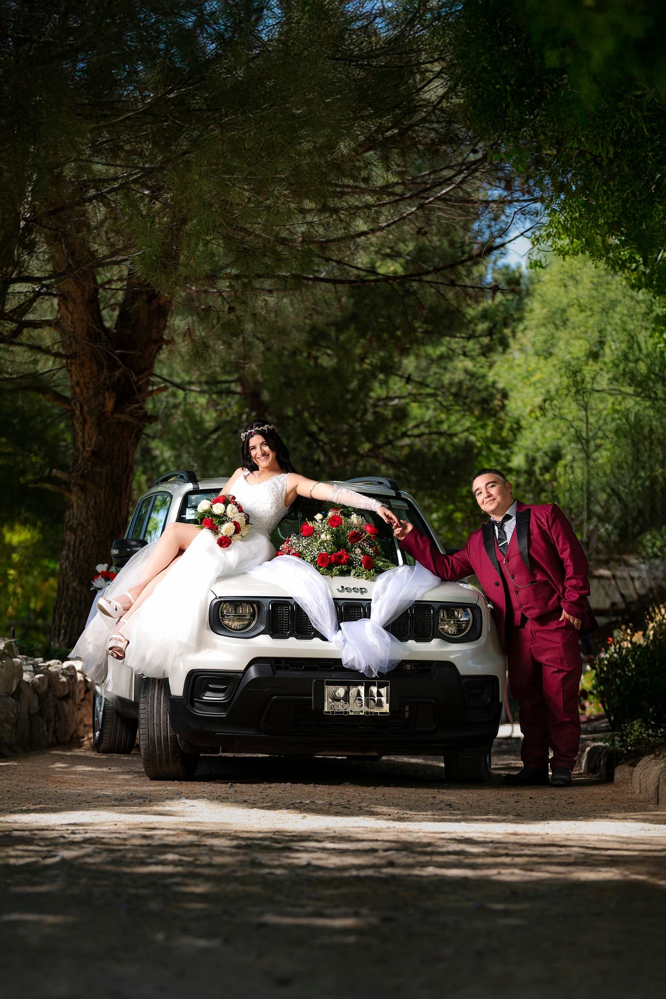 Pareja de boda junto a automóvil decorado